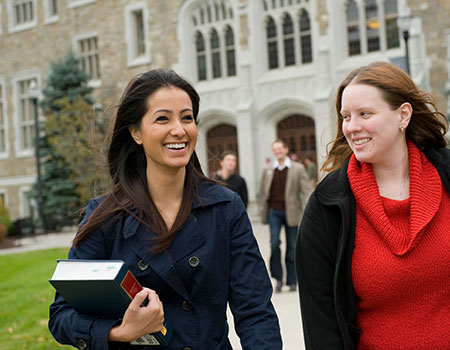 2 female Albany Law student walking and smiling